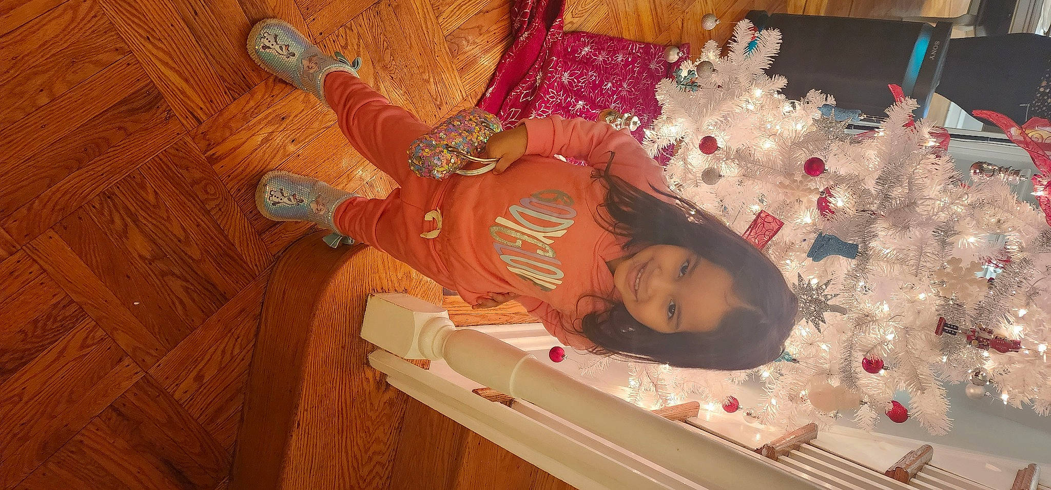 Hailee is registered to the contest to win money with this photo: baby, baby_safety, baby_toddler_clothing, child, christmas, christmas_decoration, christmas_eve, event, flooring, hardwood, holiday, joy, pattern, peach, person, room, toddler, varnish, wood, wood_stain