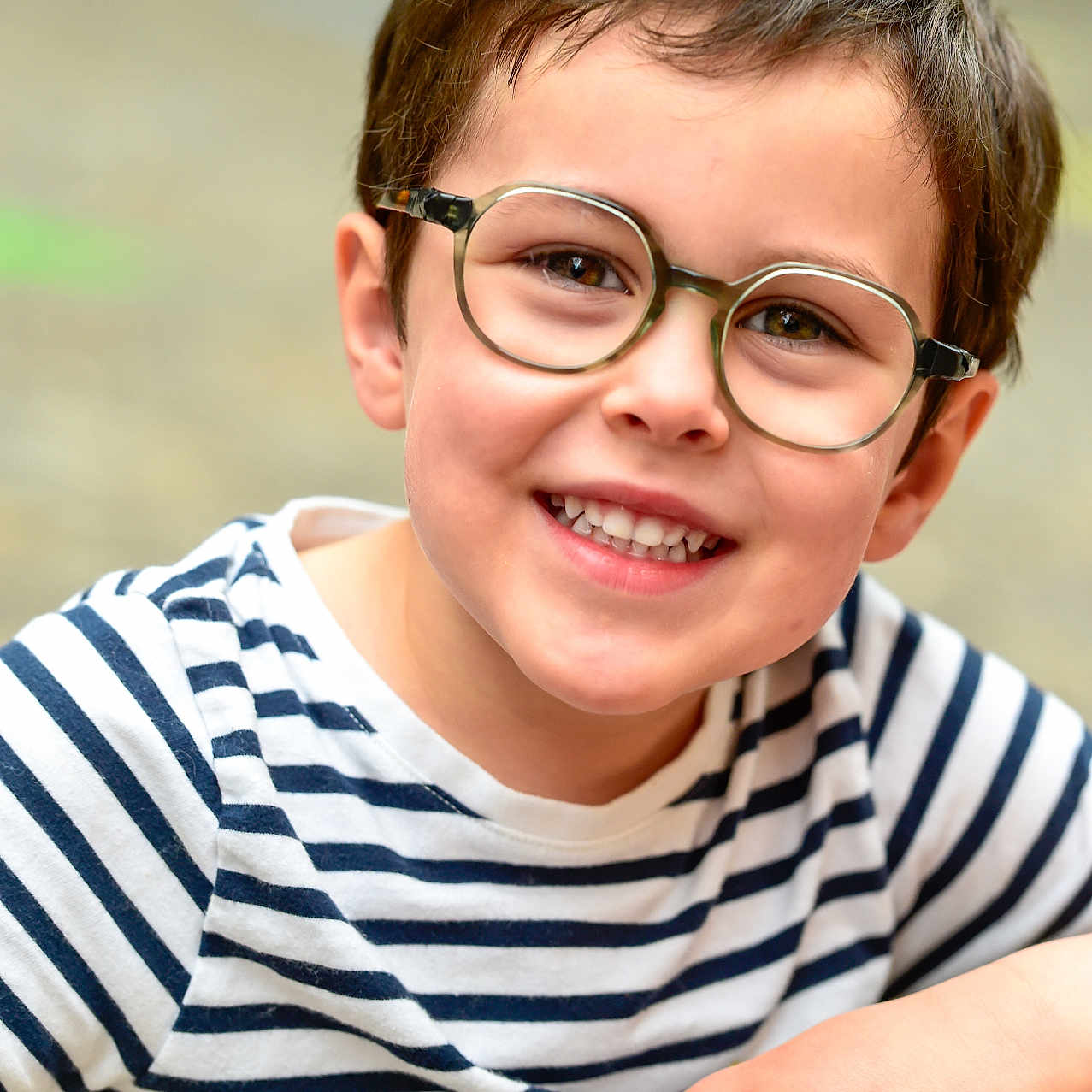 Roméo a rejoint le concours — aidez-le/la à gagner de superbes lots ! child, boy, glasses, smile, striped_shirt, happy, portrait, face, casual_clothing, short_hair, young, person, cute, friendly, outdoor, daylight, closeup, brown_hair, eyewear, joyful