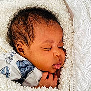 Avana is registered to the contest to win money with this photo: baby, sleeping, blanket, soft, cozy, infant, face, child, curly_hair, clothing, cute, resting, peaceful, newborn, portrait, wrapped, comfort, bedtime, white, hand