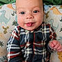 Quentin is registered to the contest to win money with this photo: baby, blanket, cheeks, closeup, clothing, cute, cute_baby, dinosaur_pattern, eyes, fabric, hand, indoor, infant, nursery, pillow, plaid_onesie, portrait, sitting, smile, tongue_out