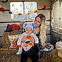 Ronnie Trevor is registered to the contest to win money with this photo: autumn, baby, bat, boots, child, halloween_decor, hat, hay, indoor, knitted_decor, long_hair, person, pillow, plaid_shirt, pumpkin, skeleton, smile, striped_clothing, window, woman