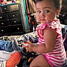 Adalina Lopez is registered to the contest to win money with this photo: baby, child, infant, sitting, bedroom, bed, blankets, pink, striped_clothing, romper, portrait, face, looking_at_camera, curious, indoors, furniture, dresser, home, soft_lighting, candid