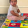 toddler, baby, child, bottle, play_mat, alphabet, colorful, floor, indoor, sitting, clothing, short_sleeve, pants, expression, face, person, carpet, toy, room, cute