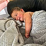 Charlee is registered to the contest to win money with this photo: baby, smiling, blanket, couch, black_leather, infant, wooden_cabinet, happy, cozy, indoor, child, face, skin, arm, furniture, relaxing, comfort, home, portrait, expression