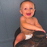 Bryar is registered to the contest to win money with this photo: baby, child, diaper, smile, happy, indoor, saddle, leather, toy, barefoot, cute, infant, face, person, skin, seated, playful, young, expression, candid