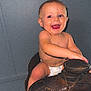 baby, child, diaper, smile, happy, indoor, saddle, leather, toy, barefoot, cute, infant, face, person, skin, seated, playful, young, expression, candid