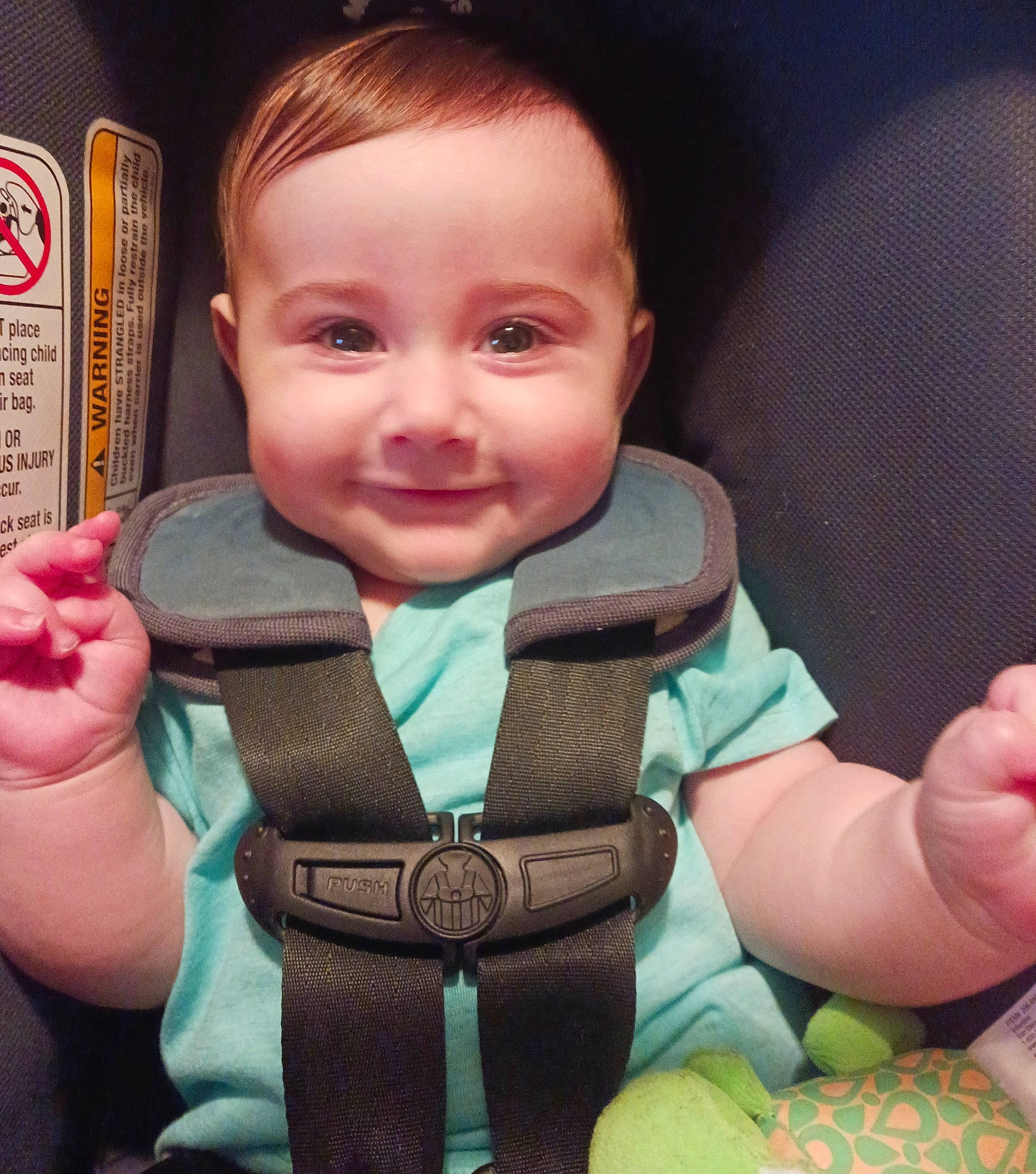 Calvin is registered to the contest to win money with this photo: baby, baby_toddler_clothing, cheek, cool, eye, eyelash, facial_expression, finger, gesture, hand, happy, human_body, joy, mouth, nose, person, pink, seat_belt, skin, sleeve