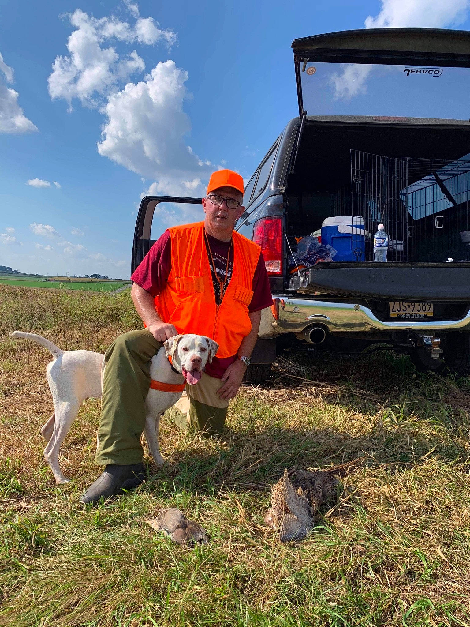 Duke is registered to the contest to win money with this photo: automotive_exterior, automotive_wheel_system, car, cloud, grass, grassland, landscape, light_commercial_vehicle, mammal, motor_vehicle, outdoor_recreation, pasture, plant, recreation, sky, sunglasses, travel, van, vehicle, vehicle_door