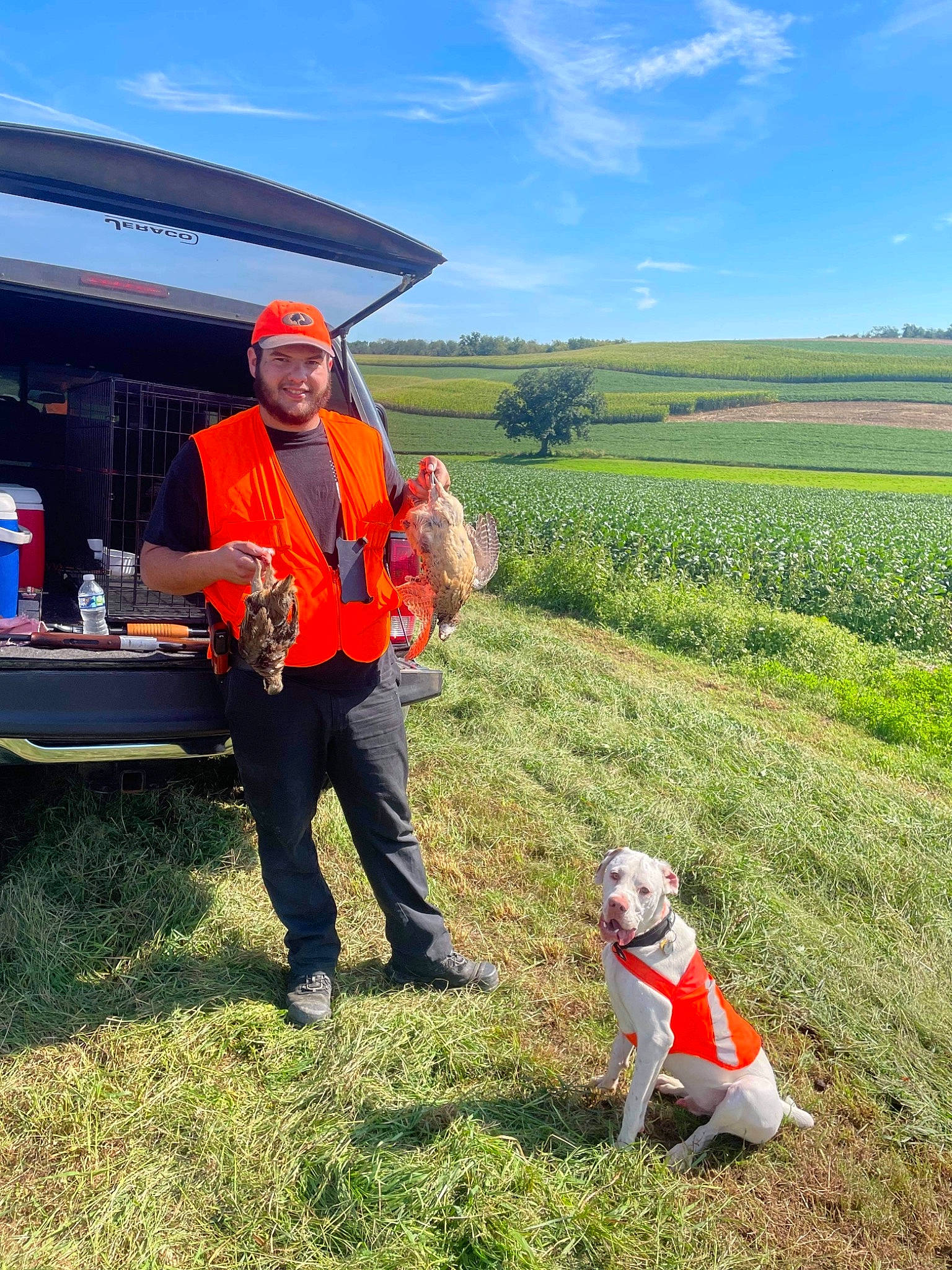 Duke joined the competition — help win amazing prizes! agriculture, carnivore, cloud, companion_dog, dog, farmer, farmworker, field, grass, grassland, landscape, people_in_nature, plant, prairie, rural_area, sky, tire, tree, vehicle, wheel