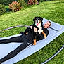 dog, man, hammock, grass, garden, outdoor, relaxing, black_clothing, happy_dog, tongue_out, greenery, plants, casual, smiling, leisure, pet, nature, daylight, lawn, fence