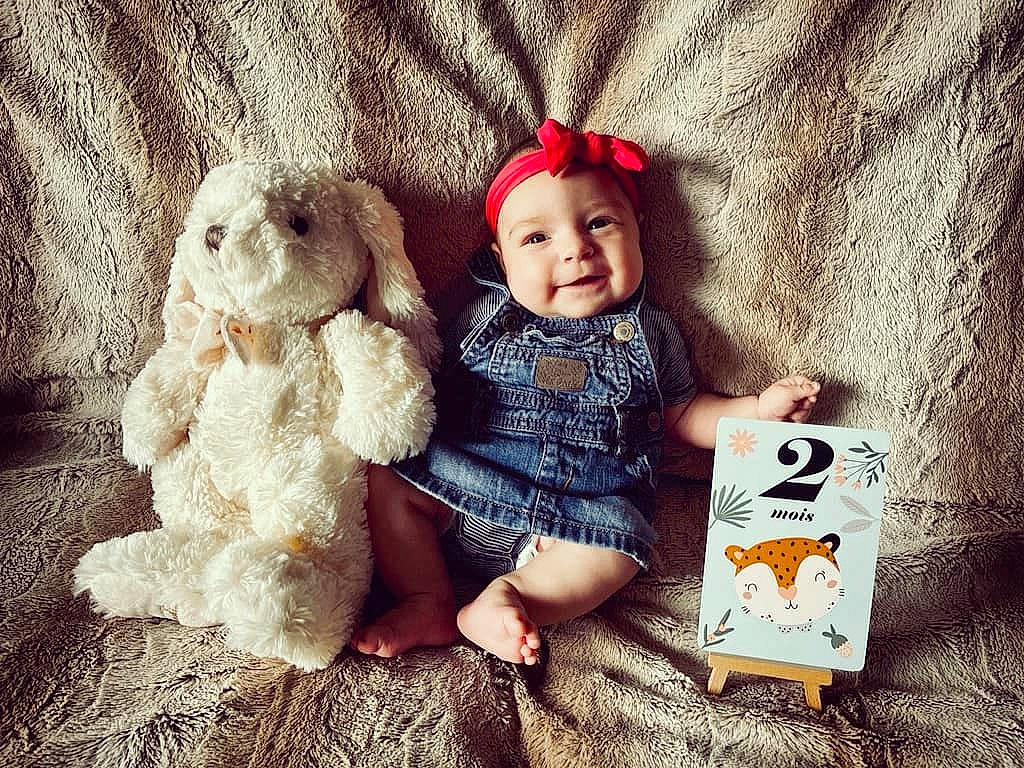 Elena a rejoint le concours — aidez-le/la à gagner de superbes lots ! baby_toddler_clothing, cap, child, doll, dress, fawn, foot, fur, happy, headgear, headwear, joy, person, sitting, skin, sleeve, smile, textile, toddler, toy