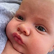 Cody joined the competition — help win amazing prizes! baby, closeup, face, pout, chubby_cheeks, skin, expression, infant, person, outdoor, gray_fabric, hand, cute, young_child, head, eyes, nose, mouth, portrait, natural_light