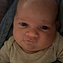 Cody is registered to the contest to win money with this photo: baby, infant, face, close_up, blanket, blue_blanket, cute, chubby_cheeks, indoors, warm_lighting, clothing, soft_texture, sleepwear, person, newborn, portrait, skin, head, eyes, expression