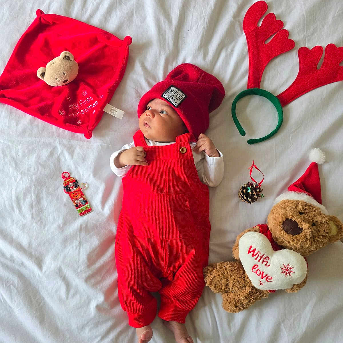 Rihan joined the competition — help win amazing prizes! baby, bed, child, christmas, christmas_hat, cute, decorations, festive, holiday, indoors, infant, lying_down, pine_cone, plush_toy, red_hat, red_overalls, reindeer_antlers, soft_toy, teddy_bear, white_bed_sheet