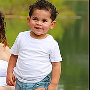 Miles joined the competition — help win amazing prizes! toddler, child, curly_hair, white_tshirt, jeans, smiling, outdoor, lake, greenery, adult_hand, tattoo, nature, grass, person, portrait, happy, young_child, casual_clothing, daylight, supporting_hand