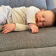 Laël participe au concours pour gagner de l'argent avec cette photo : baby, sleeping, couch, gray, pajamas, infant, peaceful, indoor, child, cozy, relaxing, soft, striped, person, furniture, home, portrait, resting, young, cute