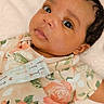 Jasmine is registered to the contest to win money with this photo: baby, infant, face, eyes, skin, person, clothing, floral, onesie, blanket, soft, lying, portrait, cute, newborn, child, indoors, young, expression, comfort