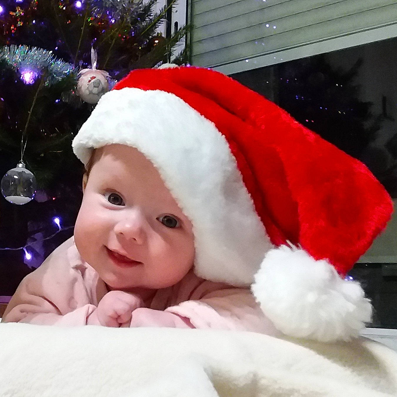 Elouann participe au concours pour gagner de l'argent avec cette photo : baby, cap, christmas, christmas_decoration, christmas_ornament, christmas_tree, costume_hat, event, fur_clothing, happy, head, headgear, headwear, holiday, holiday_ornament, human_body, lap, ornament, person, santa_claus