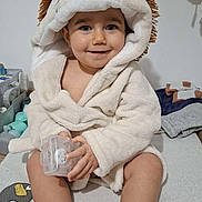 Noah participe au concours pour gagner de l'argent avec cette photo : baby, toddler, child, hooded_towel, lion_costume, bathrobe, smile, sitting, pacifier_case, blue_eyes, plush_toy, birthday_banner, nursery, indoor, hands, feet, toy_storage, soft_texture, portrait, cute
