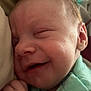 Cooper is registered to the contest to win money with this photo: baby, smiling, close_up, sleeping, infant, face, hand, clothing, green_shirt, soft_light, resting, cute, newborn, peaceful, skin, indoors, portrait, happy, child, young