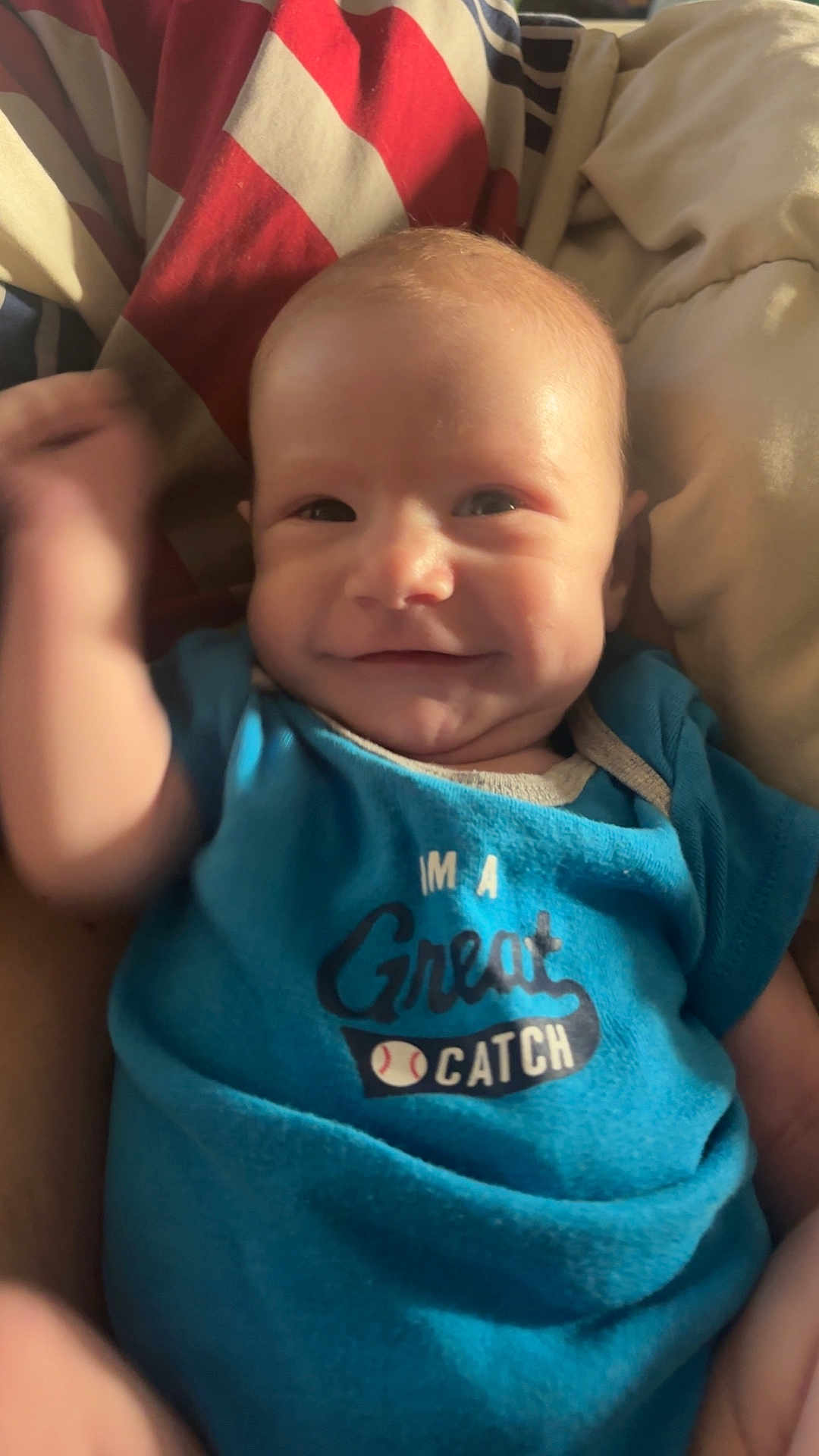Cooper joined the competition — help win amazing prizes! baby, smiling, onesie, blue_clothing, infant, face, hand, blanket, cozy, cute, happy, portrait, young_child, indoor, soft_light, cheerful, person, waving, clothing, baby_garment
