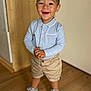 Nayan a rejoint le concours — aidez-le/la à gagner de superbes lots ! toddler, smiling, child, indoor, standing, casual_clothing, shorts, polo_shirt, sneakers, wooden_floor, happy, portrait, young_child, playful, cute, person, real_photo, light_blue, beige, short_hair