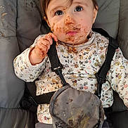 Jade a rejoint le concours — aidez-le/la à gagner de superbes lots ! child, toddler, messy, face_paint, food_smear, high_chair, straps, clothing, floral_pattern, indoor, curious_expression, brown_hair, long_sleeves, pants, seat, baby, cute, portrait, messy_hands, young_child