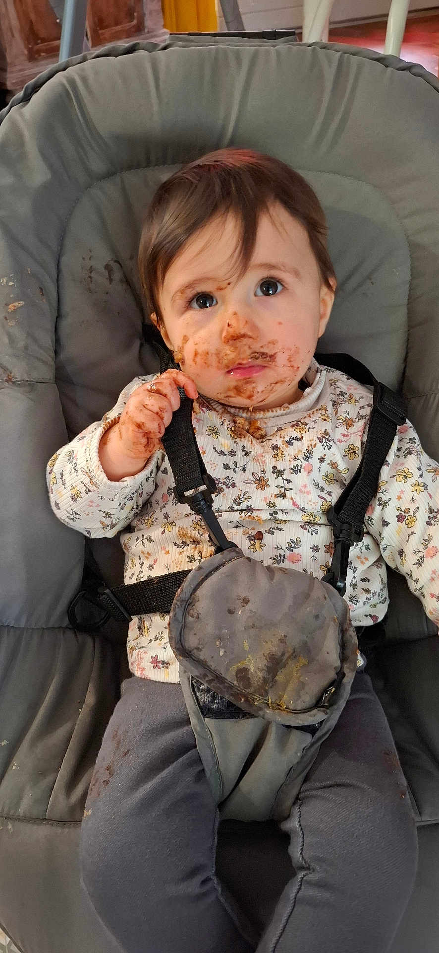 Jade a rejoint le concours — aidez-le/la à gagner de superbes lots ! child, toddler, messy, face_paint, food_smear, high_chair, straps, clothing, floral_pattern, indoor, curious_expression, brown_hair, long_sleeves, pants, seat, baby, cute, portrait, messy_hands, young_child