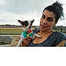 Peewee joined the competition — help win amazing prizes! dog, woman, pet, portrait, selfie, outdoor, sports_field, stadium, cloudy_sky, small_dog, chihuahua, shirt, collar, medal, leash, person, animal, holding, tattoo, fence