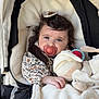 baby, infant, stroller, pacifier, blanket, plush_toy, floral_print, hair_clip, white_fabric, cozy, portrait, cute, face, hand, toy, seat, hood, fur_lining, nap_time, carriage