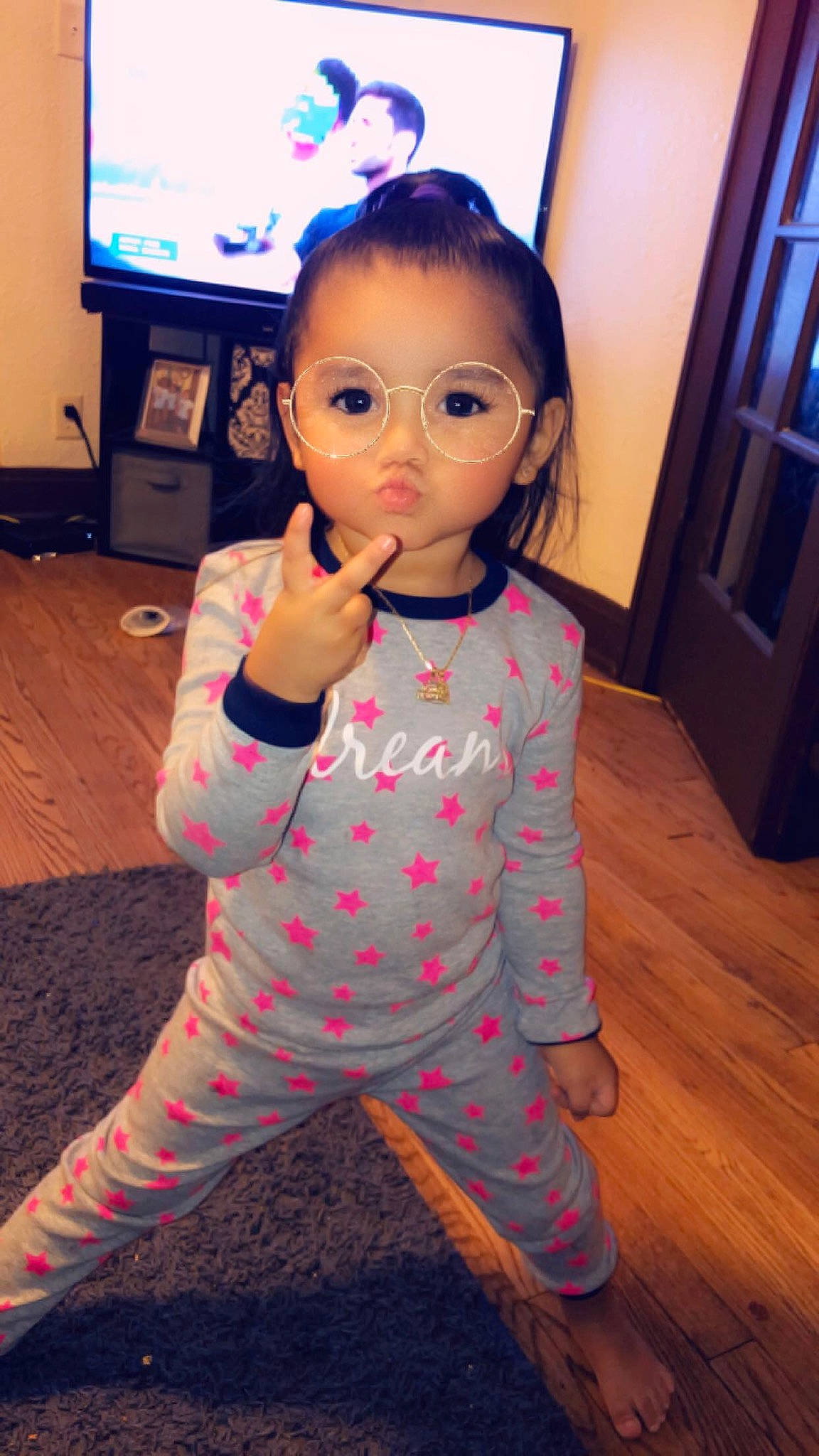 Miracle is registered to the contest to win money with this photo: baby, cheek, child, face, head, lip, pajamas, person, pink, skin, sleeve, standing, thumb, toddler