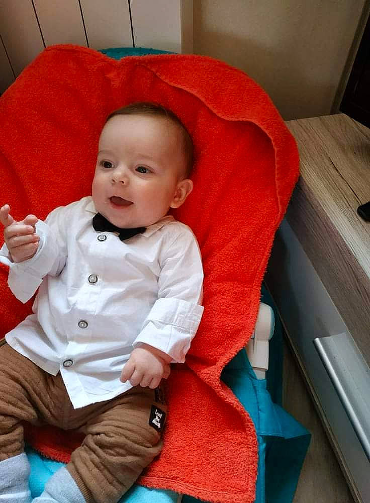 Lyam participe au concours pour gagner de l'argent avec cette photo : baby, baby_toddler_clothing, cheek, child, collar, comfort, eye, fun, hairstyle, happy, head, mouth, outerwear, person, sitting, skin, sleeve, smile, t_shirt, textile