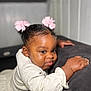 Eliana-Brielle is registered to the contest to win money with this photo: baby, girl, child, pink_bows, hair_bows, white_dress, texture, face, skin, hand, curious, leaning, couch, furniture, indoor, portrait, closeup, cute, expression, soft_light