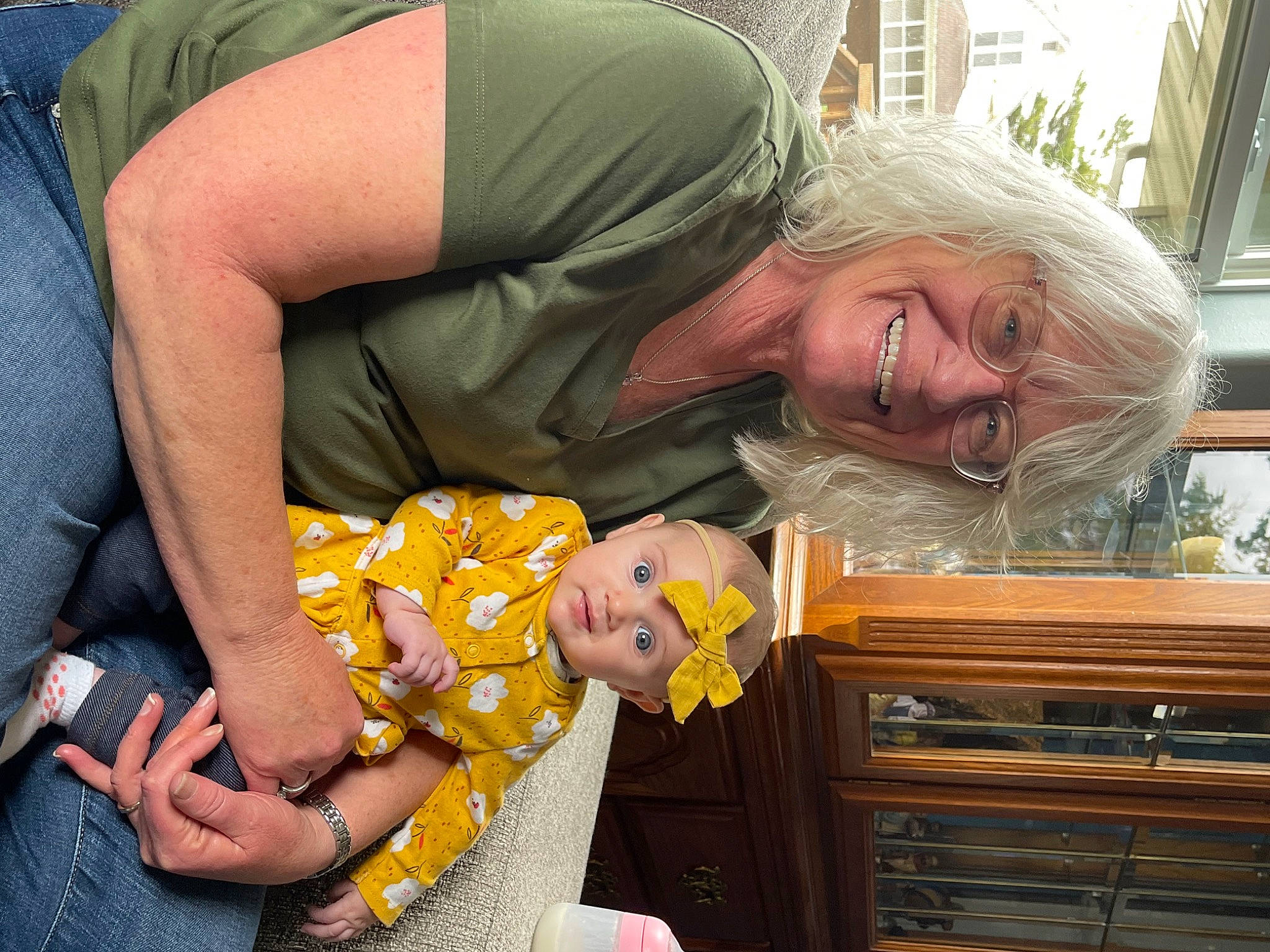 Anika is registered to the contest to win money with this photo: cabinetry, chest_of_drawers, child, cupboard, drawer, dresser, event, fun, gesture, grass, hand, happy, headwear, joy, lap, laugh, mammal, person, photograph, sitting