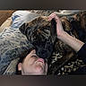 dog, brindle_dog, pet, person, face, selfie, nose_boop, affectionate, playful, bed, pillow, blanket, bedroom, indoors, cuddling, petting, close_up, funny, animal, portrait
