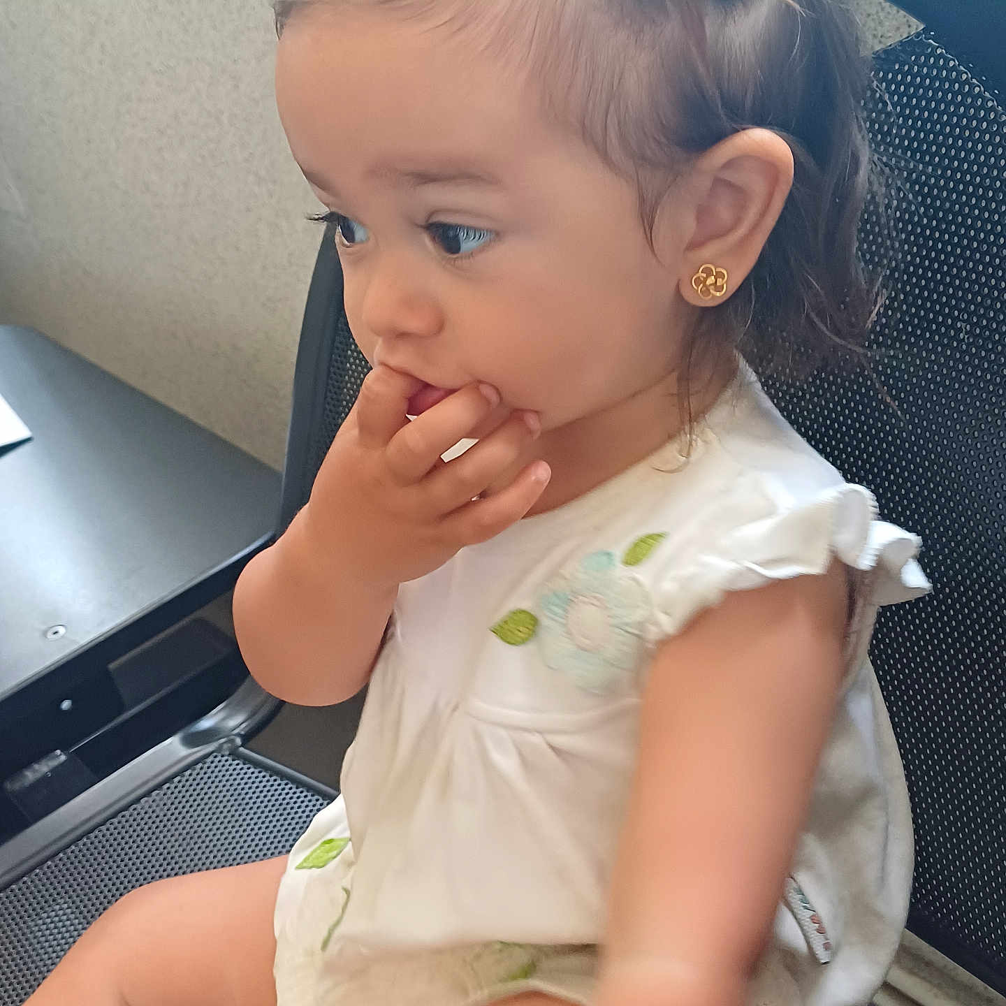 Olina participe au concours pour gagner de l'argent avec cette photo : baby, casual, chair, child, curious, cute, earrings, fingers_in_mouth, flower_embroidery, girl, hair_clip, indoor, looking_away, mesh_chair, person, portrait, sitting, toddler, white_dress, young_child