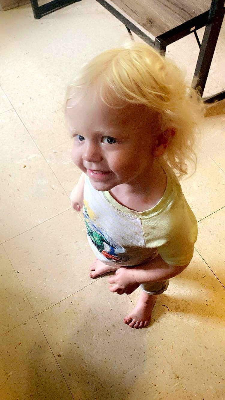 Axel joined the competition — help win amazing prizes! child, toddler, blonde_hair, barefoot, smiling, indoor, floor, tile_floor, table, wooden_table, curly_hair, happy, person, standing, casual_clothing, short_sleeve_shirt, cute, playful, young_child, light