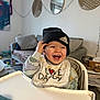 Jules a rejoint le concours — aidez-le/la à gagner de superbes lots ! adidas, baby, beanie, bib, child, food, hat, highchair, laughing, living_room, messy, mirror, pillow, smile, snack, sofa, string_lights, toddler, toys, wall_art