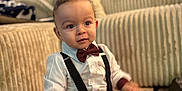 Jules participe au concours pour gagner de l'argent avec cette photo : baby, big_eyes, bow_tie, carpet, child, couch, cozy, curly_hair, cute, decorations, formal_outfit, indoor, living_room, maroon_pants, portrait, sitting, smiling, suspenders, toddler, white_shirt