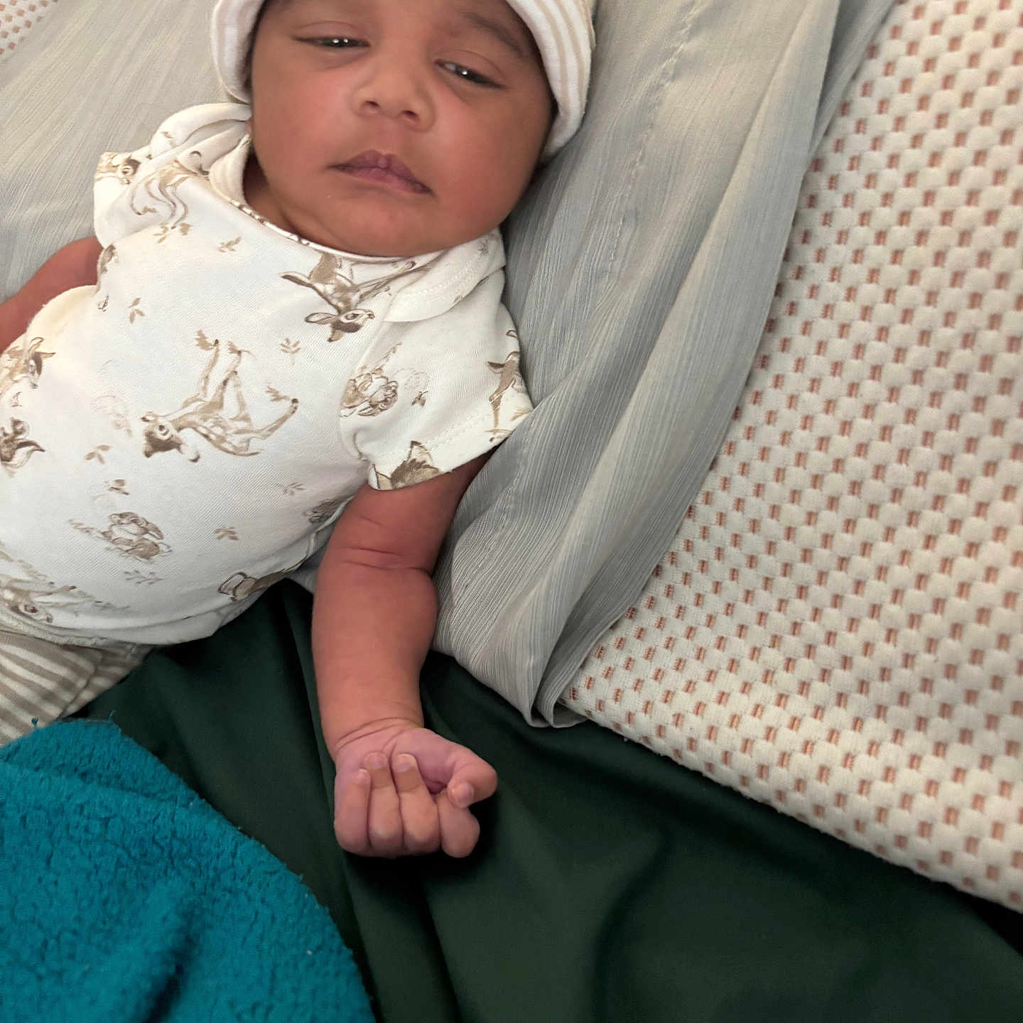 Micah Jackson is registered to the contest to win money with this photo: baby, bed, blanket, child, cute, furniture, hand, hat, indoors, infant, lying_down, onesie, pattern, person, pillow, portrait, resting, skin, sleepy, textile