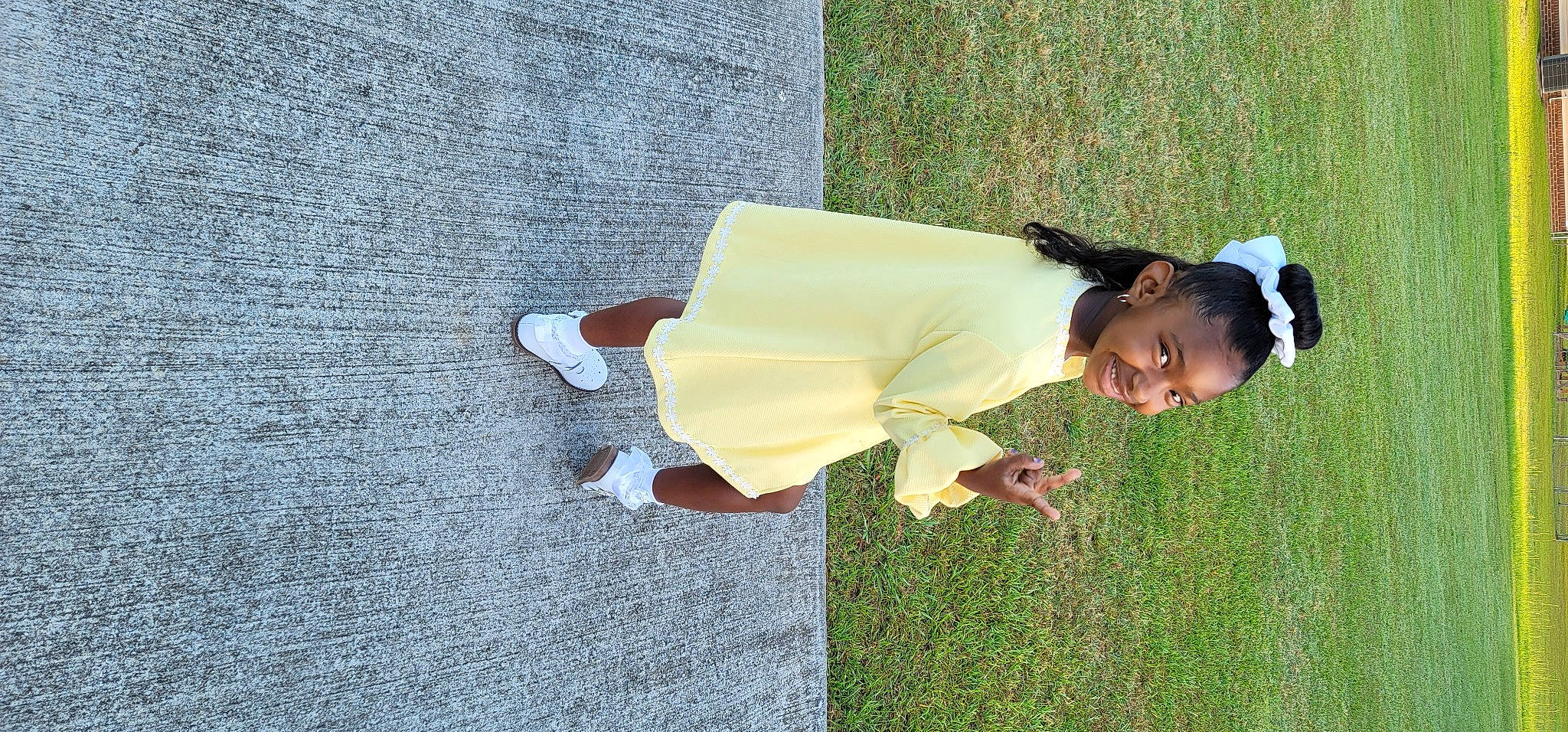 Amari Rowe is registered to the contest to win money with this photo: child, face, flooring, fun, grass, happy, human_leg, joy, lawn, leisure, people_in_nature, person, plant, recreation, shadow, sitting, smile, sunglasses, toddler