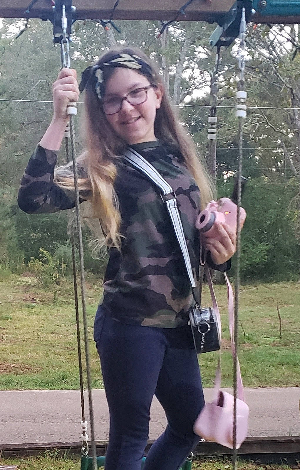 Hayley is registered to the contest to win money with this photo: adventure, bag, clothing, electric_blue, fashion_accessory, fun, fur, grass, joy, knee, leisure, luggage_and_bags, magenta, person, plant, recreation, rope, smile, strap, t_shirt