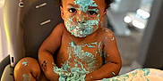Tyrion Jr joined the competition — help win amazing prizes! toddler, child, high_chair, cake, blue_frosting, messy, face_paint, smudged, birthday, indoor, cartoon_background, curly_hair, chubby_cheeks, food_play, happy_mess, young_child, cute, playful, celebration, kitchen