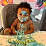 toddler, child, high_chair, cake, blue_frosting, messy, face_paint, smudged, birthday, indoor, cartoon_background, curly_hair, chubby_cheeks, food_play, happy_mess, young_child, cute, playful, celebration, kitchen
