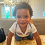 Tyrion Jr joined the competition — help win amazing prizes! toddler, child, smiling, curly_hair, table, indoor, couch, hand, marble_surface, window, light, chandelier, shirt, shorts, happy, person, portrait, baby, cute, support
