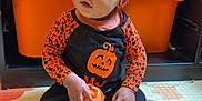 Nelson participe au concours pour gagner de l'argent avec cette photo : baby, child, halloween_outfit, pumpkin_design, orange_clothing, play_mat, toy, sitting, indoors, storage_bin, shelf, plastic_toy, headwear, cute, infant, footwearless, expression, face, person, playroom