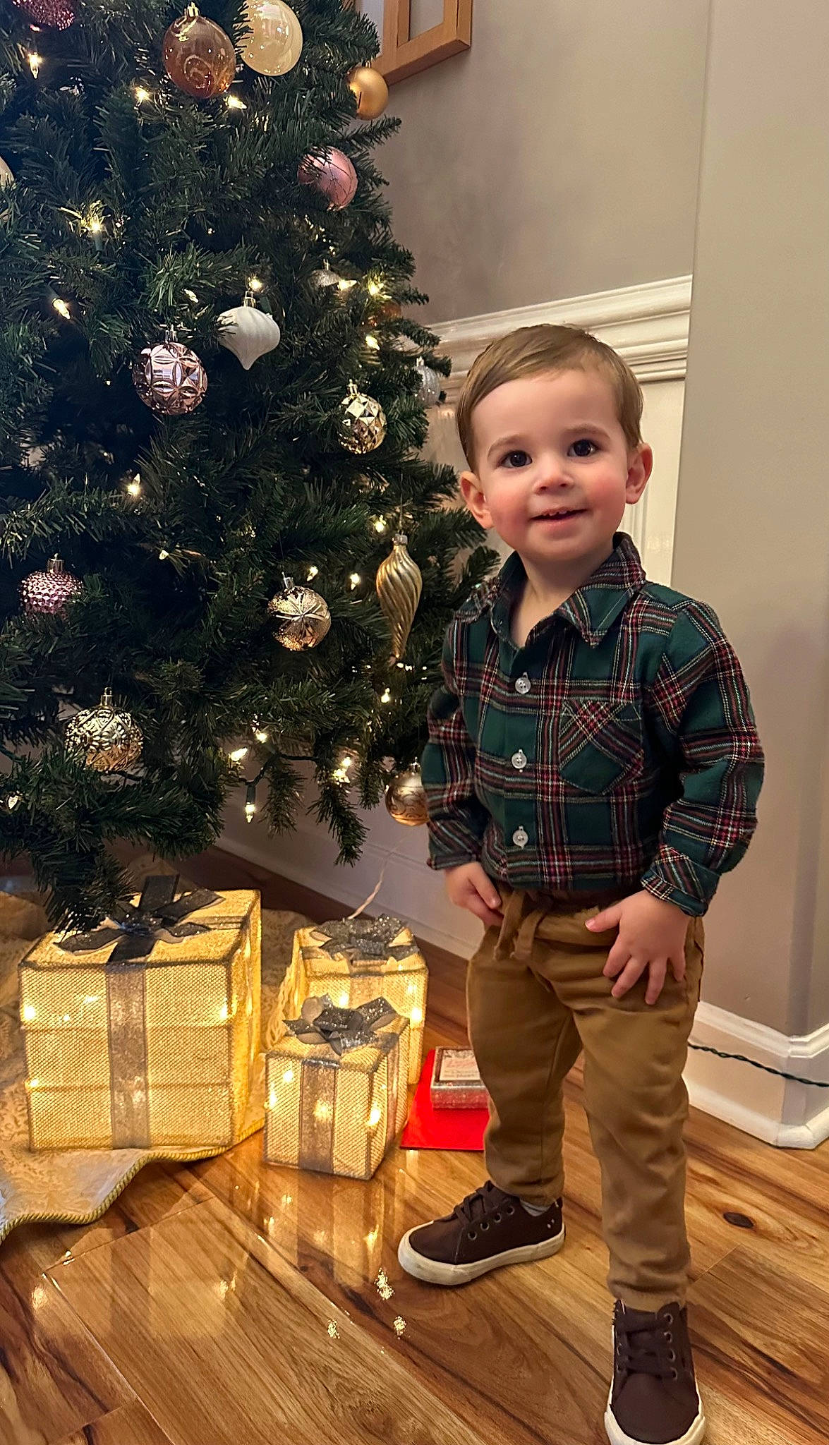 Kasper is registered to the contest to win money with this photo: christmas, christmas_decoration, christmas_eve, christmas_ornament, christmas_tree, event, evergreen, happy, holiday, holiday_ornament, joy, ornament, person, plaid, plant, sleeve, smile, standing, tartan, toddler