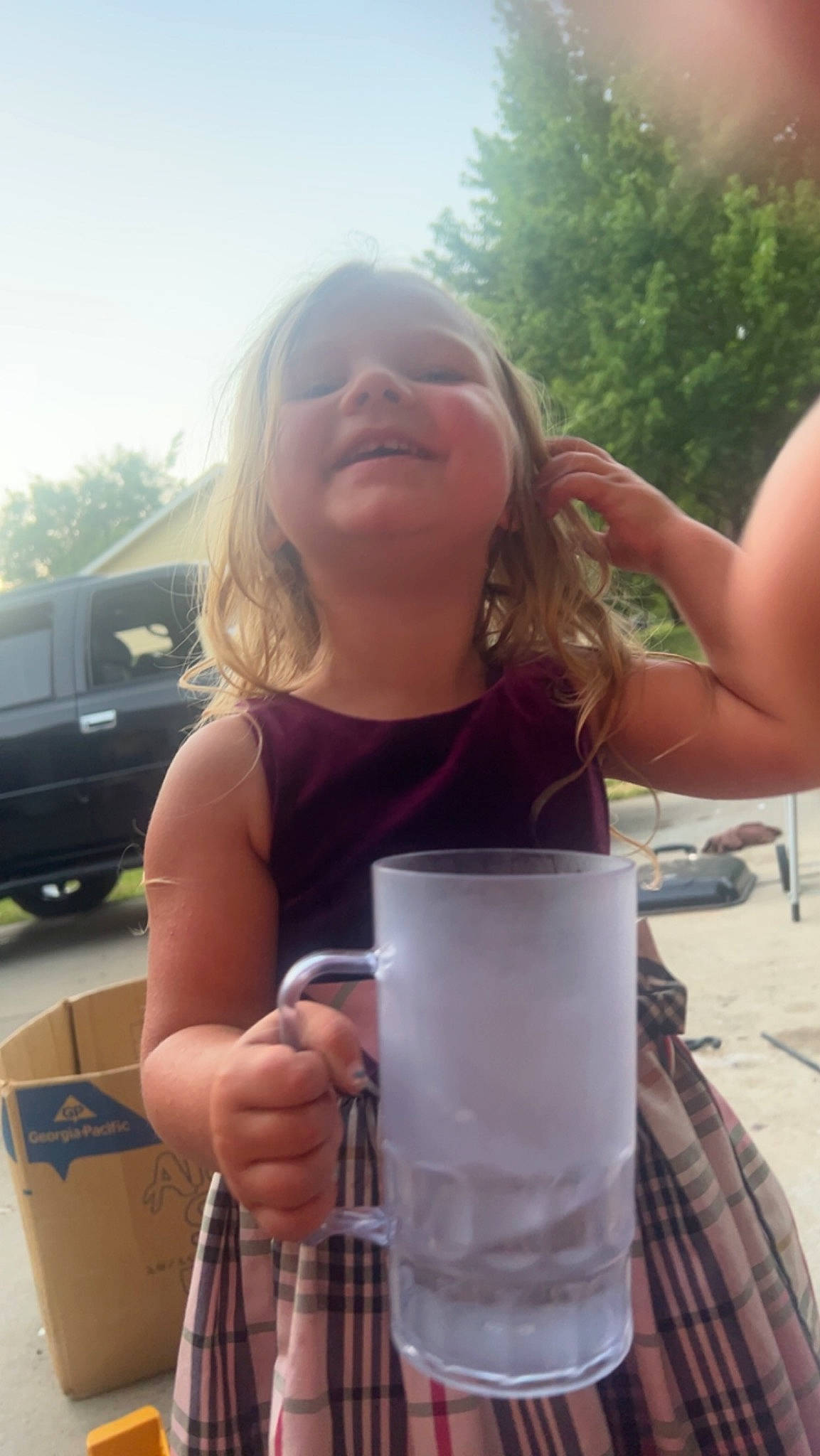 Athena is registered to the contest to win money with this photo: blond, car, cup, drink, drinking, drinkware, finger, fun, glass, happy, human_leg, leisure, person, sky, summer, t_shirt, tableware, thumb, tree, vacation