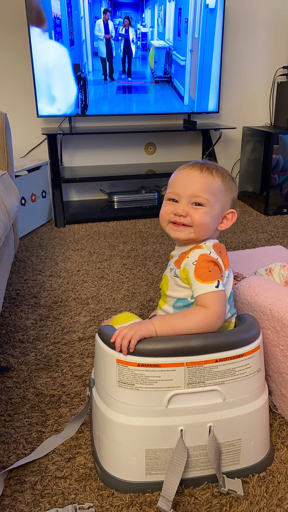 Nala is registered to the contest to win money with this photo: baby, baby_toddler_clothing, blue, child, comfort, computer_monitor_accessory, electronic_device, floor, flooring, fun, gadget, home_appliance, joy, output_device, person, product, smile, standing, technology, television