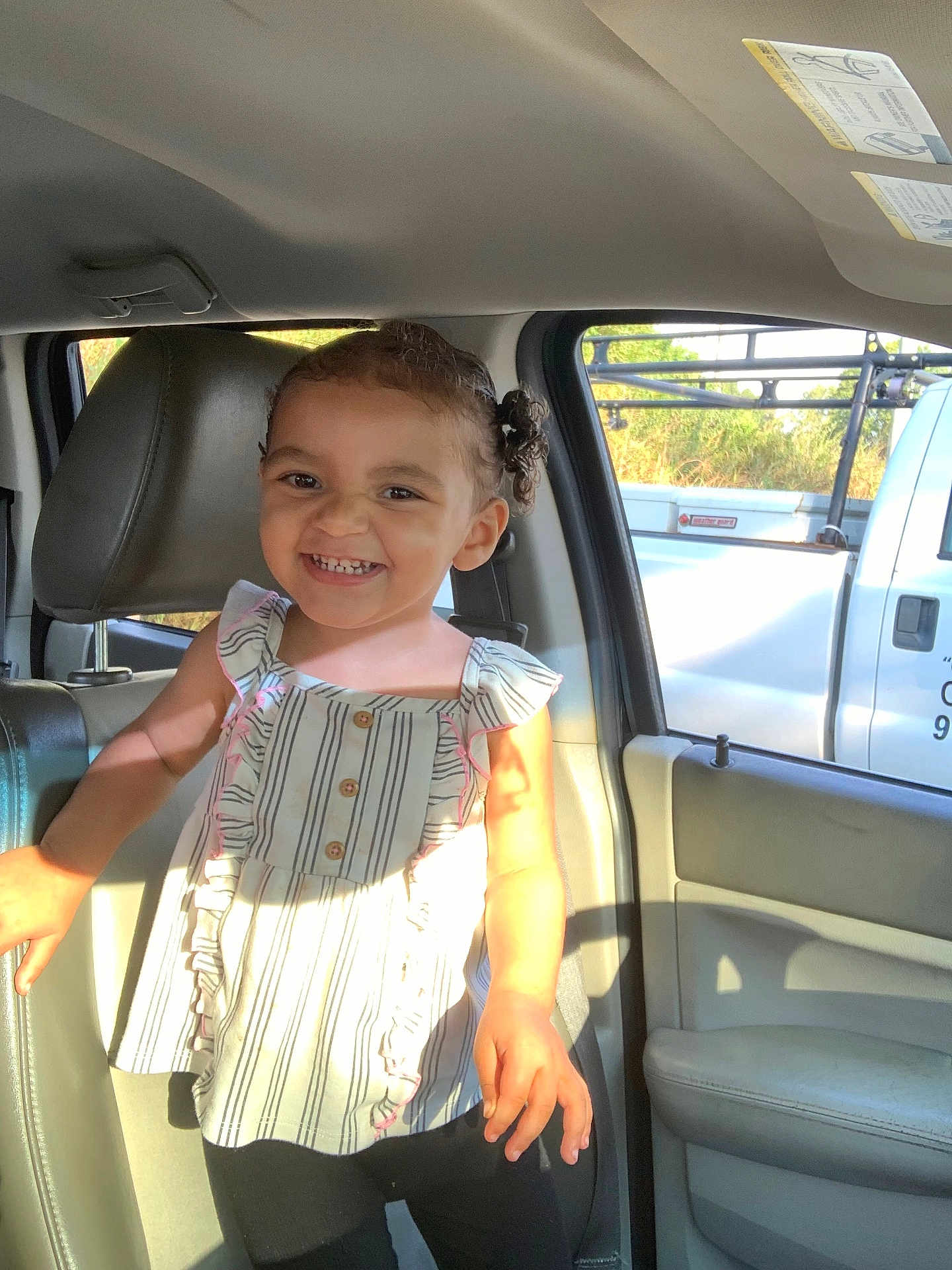 Trinity joined the competition — help win amazing prizes! child, toddler, smiling, inside_car, sunlight, curly_hair, striped_top, frills, happy, seat, car_door, window, shadow, daylight, person, portrait, clothing, young_child, cute, bright